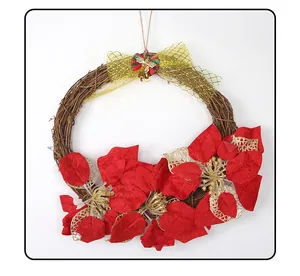 Close-up of a Christmas vine wreath with red poinsettias and golden mesh bow