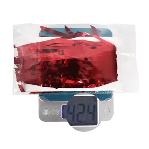 Weight measurement showing 42.4g for red foil fringe Christmas party decoration.