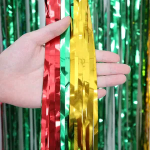 Close-up of red, green, and gold metallic foil fringe curtains for Christmas party decor.