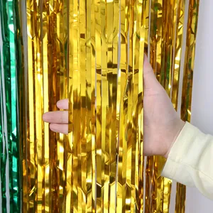 Close-up of shiny gold and green metallic tinsel fringe curtain for Christmas party decoration