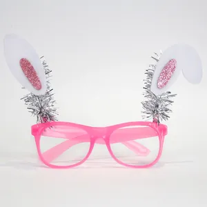 Detalle de gafas rosas de orejas de conejo de Pascua con purpurina y espumillón.