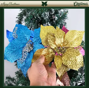 Hand holding 22cm blue and gold artificial glitter poinsettia flowers for Christmas tree decor