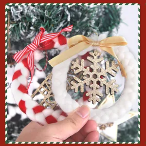 Detail view of plush Christmas wreath ornaments with golden snowflake and ribbon