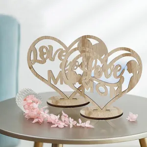 Detailed view of wooden heart-shaped ornaments engraved with "Love MOM" on a tabletop.