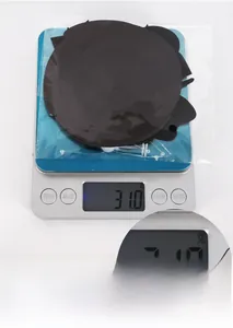 Close-up detail of black party spiral decoration on a digital scale weighing 31.0 grams.