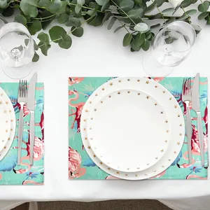 Vibrant tropical flamingo pattern fabric placemat on a white table with dinnerware