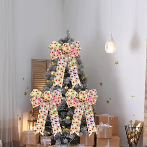 Trois nœuds de Noël à LED en toile de jute étoilée pour sapin dans un salon chaleureux.