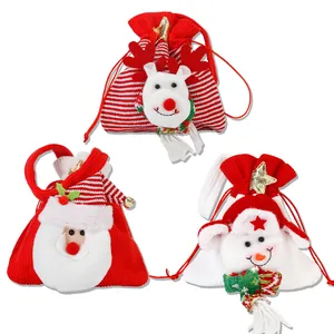 Détail de trois sacs cadeaux de Noël à cordon avec Père Noël, renne et bonhomme de neige