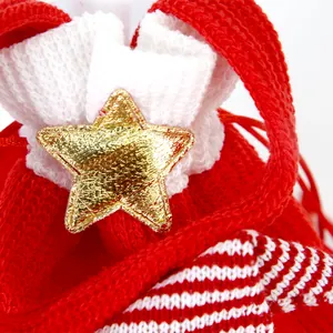 Gros plan d'une étoile dorée sur un sac cadeau de Noël en tricot rouge et blanc décoré