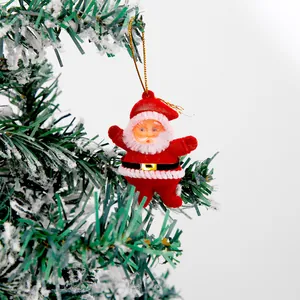Close-up of a red flocked Santa Claus hanging ornament on a snowy Christmas tree