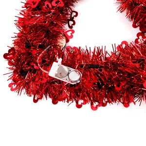 Macro detail of the white battery box with two CR2032 button cells for the red tinsel wreath