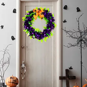 Festive Halloween wreath in purple and green with orange spider bow on a door