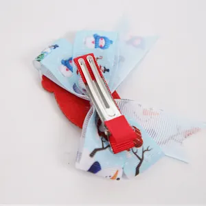 Kids Christmas hair clip featuring snowman print blue ribbon and red bow accessory