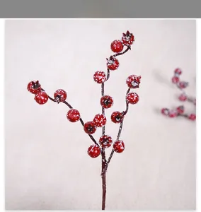 Gros plan de baies rouges artificielles avec neige pour décoration de Noël.