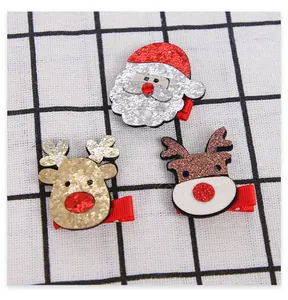 Close-up of glittery Christmas hair clips featuring Santa Claus and reindeer designs
