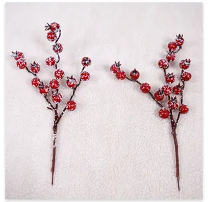Macro shot of artificial red berries with realistic snow for Christmas DIY decor