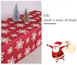 Dettaglio di tovaglia natalizia rossa con fiocchi di neve per decorazioni festive.