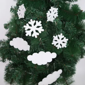 Close-up of white foam snowflake and cloud ornaments on a green Christmas tree