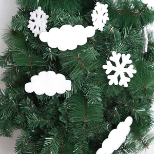 Close-up of white foam snowflake and cloud ornaments on a green Christmas tree