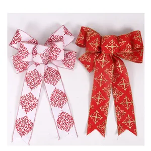 Par de lazos navideños decorativos en rojo y blanco con motivos de copos brillantes