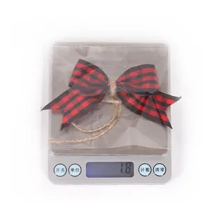 Detailed close-up showing the 1.8g weight of a red and black plaid Christmas bow pendant