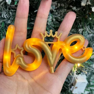Close-up van warm gouden LOVE LED-bord met kroon voor romantische en sfeervolle decoratie.