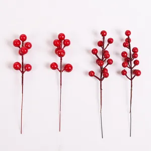 Vue détaillée de quatre tiges de baies rouges artificielles pour les décorations de Noël.