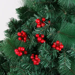 Gros plan de grappes de baies rouges artificielles sur des branches de sapin de Noël.