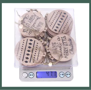 Set de adornos de Navidad de madera en caja, pesan 47,1 g en una báscula digital