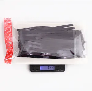 Detail shot of black laser foil fringe curtain in packaging showing weight on a scale