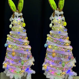 Detailansicht des weißen Osterbaums mit leuchtenden LED-Bandlichtern und bunten Eiern.
