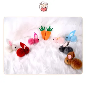 Detailed view of colorful plush rabbit and carrot hair clips on soft white fur