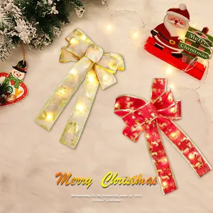 Detail showing LED Christmas bows with warm glowing lights and reindeer patterns for tree