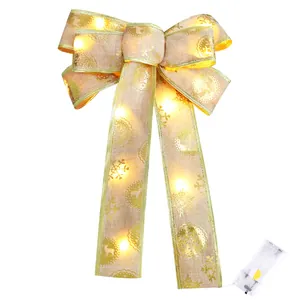 Glowing Christmas bow ornament with gold trim and warm LED lights for tree decoration