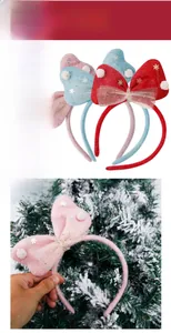 Detailed view of a pink Christmas bow headband with snowflake sequins and soft pom-poms