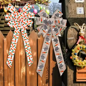 Pair of festive Easter decorative bows featuring rabbit and carrot prints on a garden fence