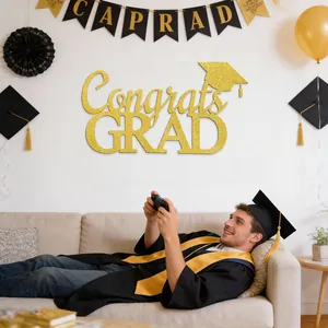 Detailed view of gold glitter Congrats GRAD wall sticker in a graduation party setting.