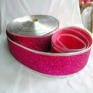 Detailopname van 5 cm roze glitter kerstlint met een zeer sprankelende textuur.