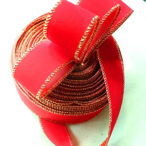Close-up of red velvet ribbon with festive gold-wired edges for Christmas decor