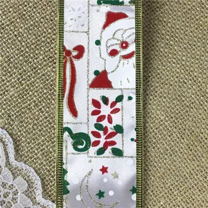Detailopname van luxe kerstlint met Kerstman-opdruk en gouden rand op jute stof.