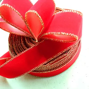 Close-up detail of luxurious red velvet Christmas ribbon with metallic gold wired edges