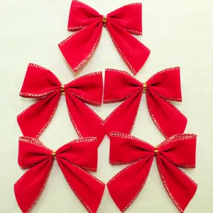 Detail view showing five red velvet Christmas bows with elegant gold metallic trim edges.