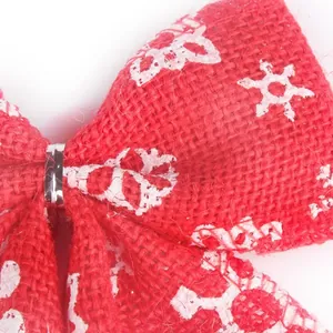 Gros plan nœud de Noël en toile de jute rouge avec motifs de flocons de neige blancs