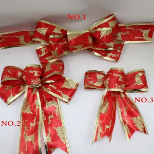 Detailed view of three festive red velvet Christmas bows with gold reindeer patterns