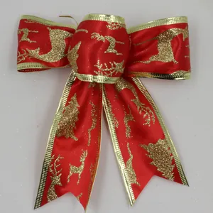 Detailed view of a festive red velvet Christmas bow with glittery golden reindeer patterns.