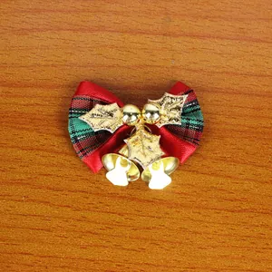 Close-up view of Christmas decorative bow with golden bells and holly leaves ornament