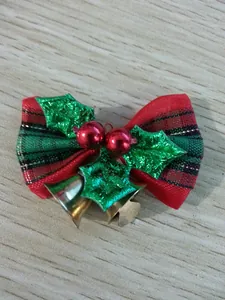 Macro view of a festive mini Christmas bow decorated with green holly leaves and gold bells