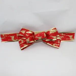 Close-up of red velvet Christmas ribbon with gold reindeer pattern and wire edges