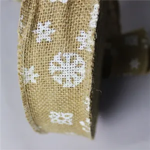 Detailaufnahme von 6 cm breitem Jute-Weihnachtsband mit weißem Schneeflockenmuster