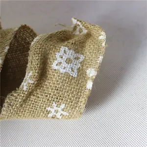 Detailansicht von natürlichem Jutewand mit weißem Schneeflocken-Druck für Weihnachtsdeko.